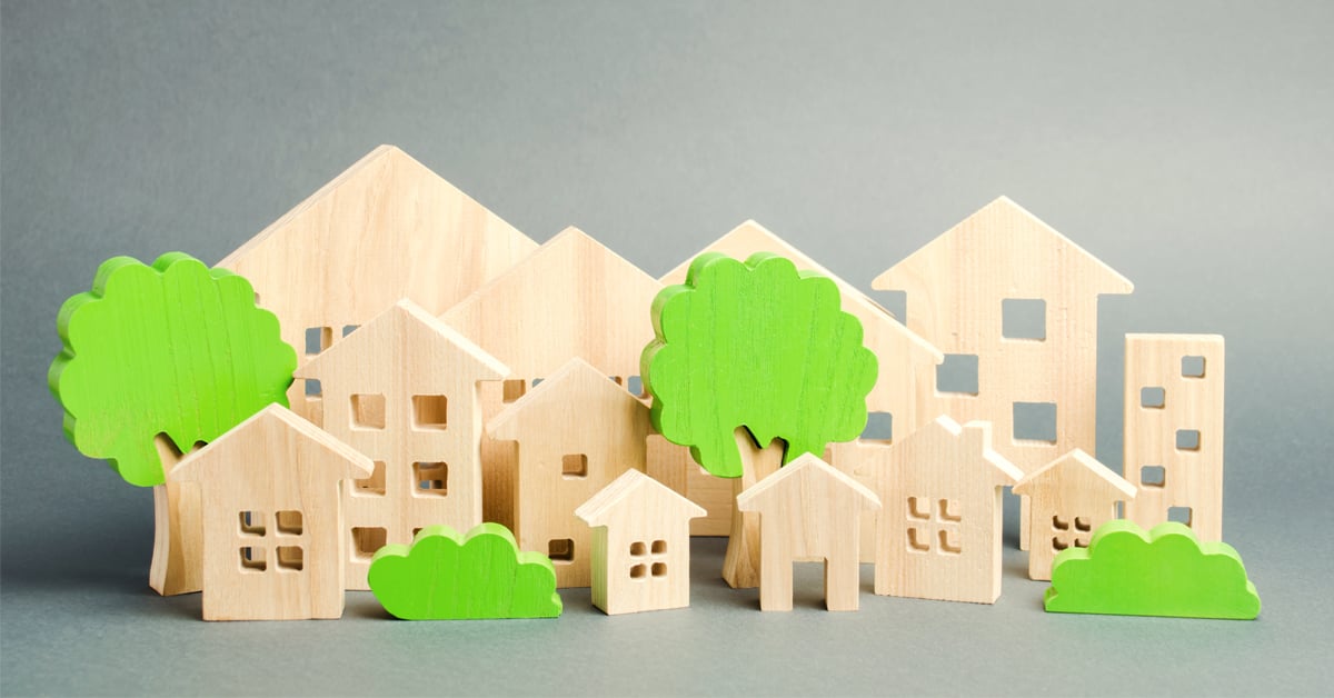 Miniature wooden toy houses and trees. Real estate concept. Architecture in the city. Infrastructure. Affordable housing. Construction of new buildings. City greening. Renovations and recovery