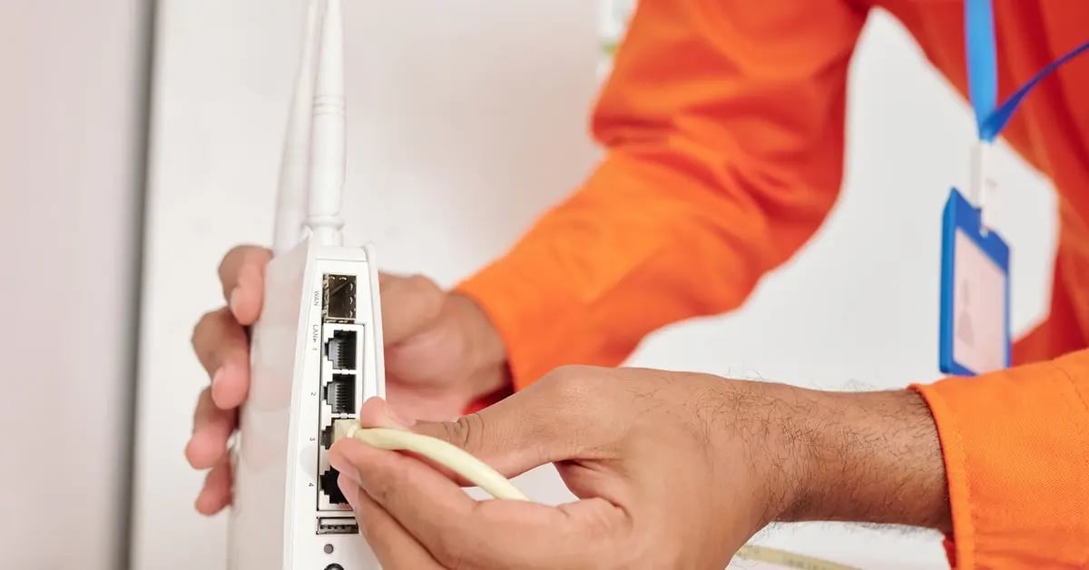 Man connecting internet cable to router