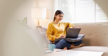 happy student at home using laptop